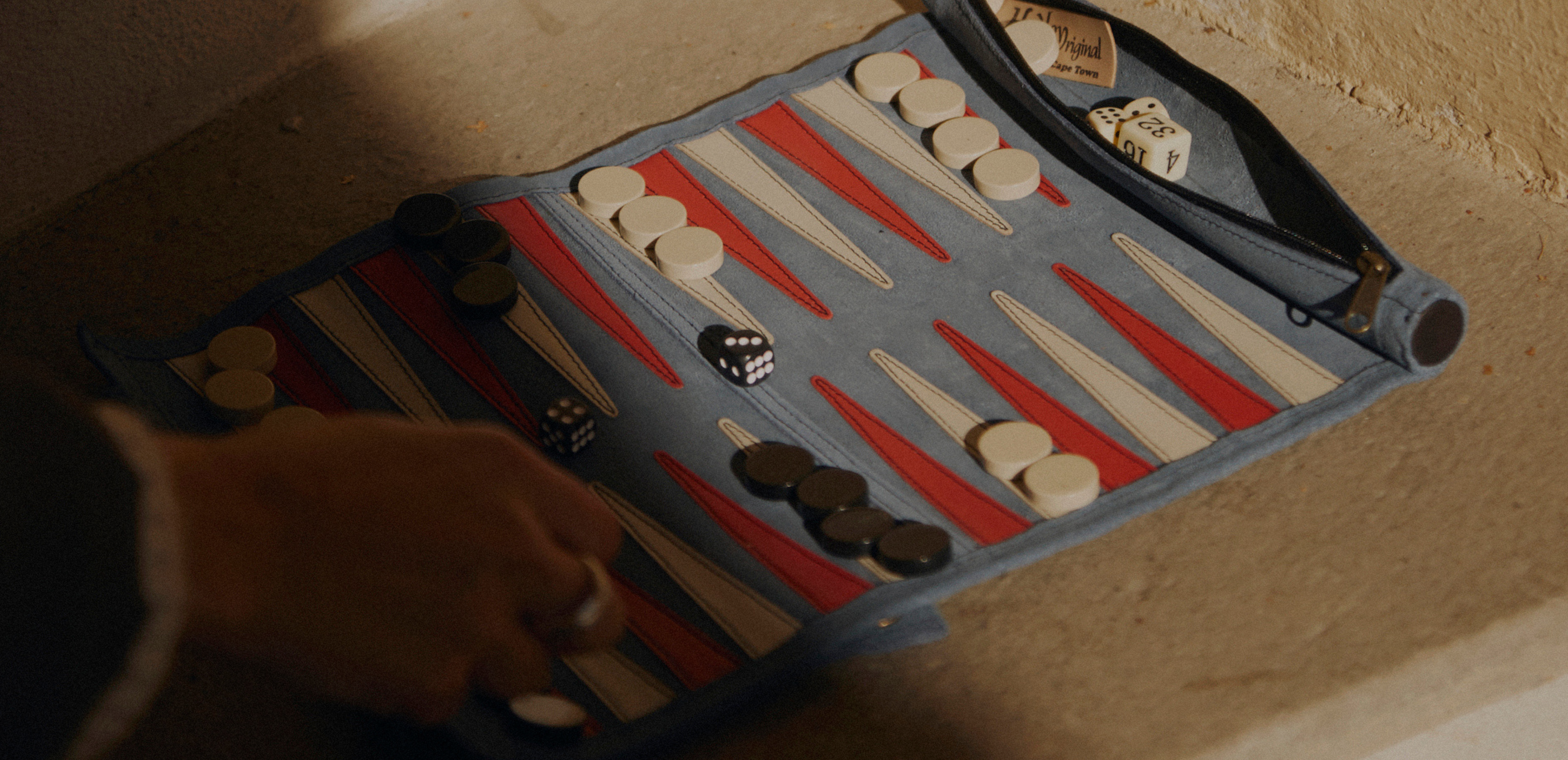 Roll-up suede backgammon set by Suede&Stone on a wooden table