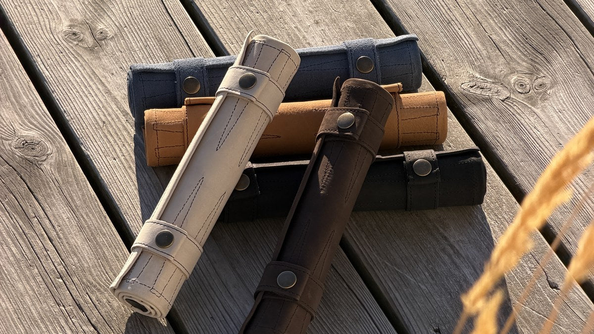 Suede and Stone travel backgammon sets in multiple colours on a wooden deck