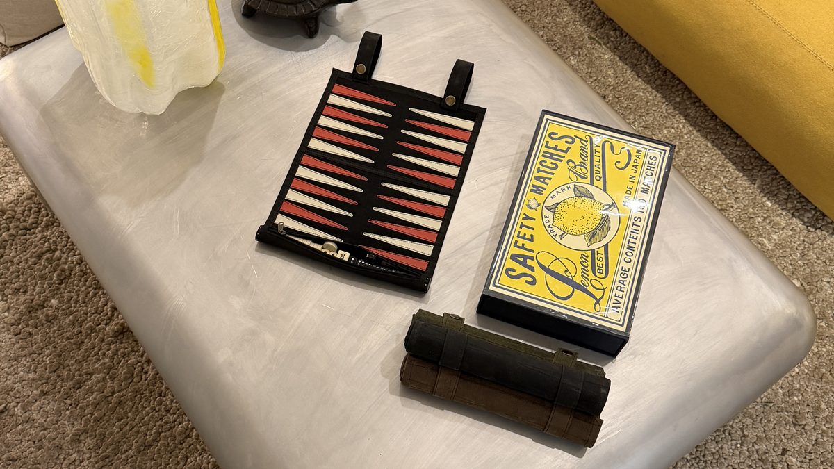 Suede and Stone backgammon set styled on a coffee table with care essentials